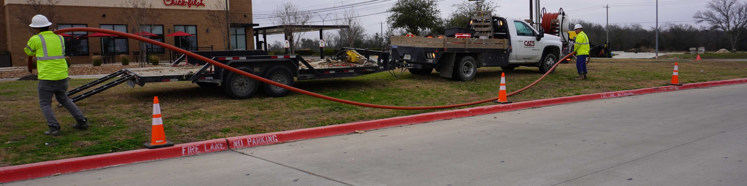CAT5 workers pulling conduit on job site